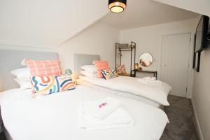 2 camas en una habitación con almohadas blancas y naranjas en Stylish 2 Bedroom Apt - Parking - 5 Mins walk to Beach, en Bournemouth