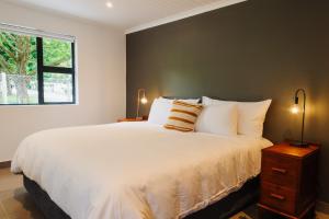 Heather Road Cottages في جورج: غرفة نوم بها سرير أبيض كبير ونافذة