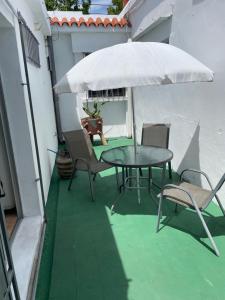 a patio with a table and chairs and an umbrella at Casa 1 habitacion in Mercedes