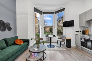 a living room with a green couch and a table at Hilldrop Apartments in London