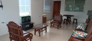 a living room with chairs and a tv and a table at Casa para 15 personas - Playas, villamil in Playas