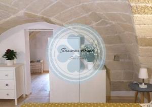 a sign in a room with a stone wall at Seasons Home San Foca in San Foca