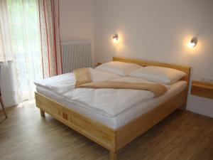 a bed with white sheets and pillows in a bedroom at Gruberbauer Remsach in Bad Gastein