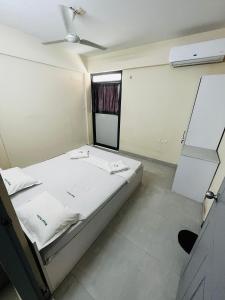 um pequeno quarto com uma cama e uma janela em REGAL SUITES em Trivandrum