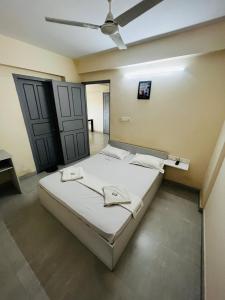 um quarto com uma cama e uma ventoinha de tecto em REGAL SUITES em Trivandrum