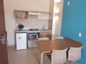 Il comprend une cuisine équipée d'une table en bois et d'un réfrigérateur blanc. dans l'établissement Eco Resort Ilhas do Lago, à Caldas Novas