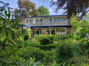 una casa con un jardín delante de ella en B&B De Slaperije, en Warnsveld