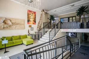 - un salon avec un canapé jaune et des escaliers dans l'établissement Honeymoon suite in Schoemansville, à Hartbeespoort