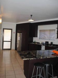 a kitchen with a counter and two bar stools at Honeymoon suite in Schoemansville in Hartbeespoort