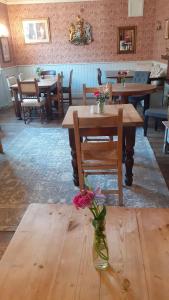 uma mesa com um vaso de flores sobre uma mesa de madeira em Fat Fox inn em Watlington