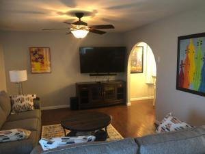 a living room with a couch and a flat screen tv at Cozy&Quiet*Fenced backyard* 17 Mins UT MktSquare in Knoxville
