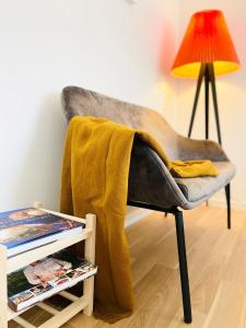 a chair with a blanket on it next to a lamp at Scandinavian Apartment Hotel - Industrimuseet - 3 room apartment in Horsens