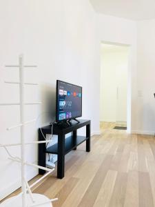 un televisor sentado en una mesa negra en una habitación en Scandinavian Apartment Hotel - Industrimuseet - 3 room apartment, en Horsens