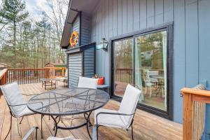 a patio with a table and chairs on a deck at Quaint Jim Thorpe Cabin Retreat, Walk to Beach! in Jim Thorpe