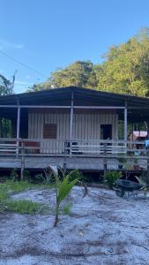 una casa con una palmera delante de ella en Camping rustico recanto do combatente, en Manaus