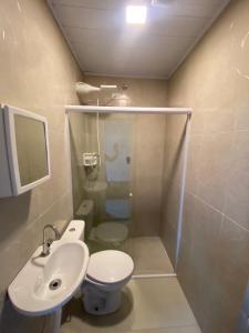 uma casa de banho com um chuveiro, um WC e um lavatório. em Casa Ceci SUÍTES/QUARTOS em São Paulo