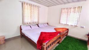 a bedroom with a bed with a red blanket on it at Sunrise Villa Coorg in Madikeri