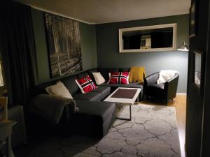 uma sala de estar com um sofá e uma cadeira em Ksu Nordlandet leiligheten em Kristiansund