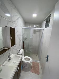 uma casa de banho branca com um WC e um lavatório em Casa Ceci SUÍTES/QUARTOS em São Paulo