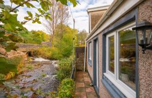 una finestra con vista sul giardino di una casa di Riverside Great House In The Afan Forest Bike Park By StayStaycations a Glyncorrwg
