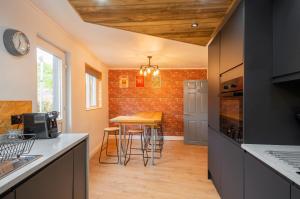 a kitchen with a counter and a table with chairs at Riverside by Afan Valley Escapes in Glyncorrwg