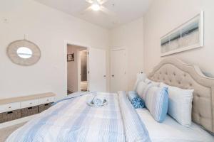 um quarto branco com uma cama grande e almofadas azuis em Cozy Apartment with WiFi em Charlotte