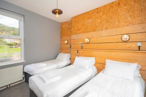2 camas individuais num quarto com uma janela em Riverside by Afan Valley Escapes em Glyncorrwg