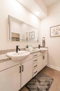 łazienka z 2 umywalkami i dużym lustrem w obiekcie Cozy Apartment with WiFi w mieście Charlotte