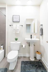 Baño blanco con aseo y lavamanos en Cozy Apartment with WiFi en Charlotte