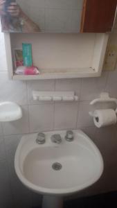uma casa de banho com um lavatório branco e um WC. em Casa Colibri em Merlo