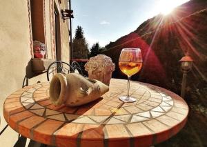 a table with a glass of wine and a statue at Narciso B&B Valbrona in Valbrona