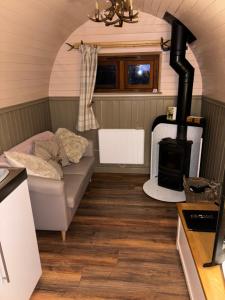 a small room with a couch and a stove at Luxury Mary's Croft with Swedish Hot tub and BBQ HUT in Shrewsbury