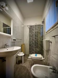 a bathroom with a sink and a toilet and a window at Albergo Italia in Porto Tolle