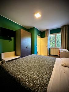 a bedroom with a large bed with green walls at Albergo Italia in Porto Tolle