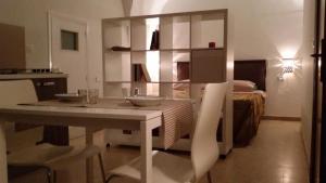 a kitchen with a table and a room with a bed at Casa Caracciolo B&B in Grottaglie