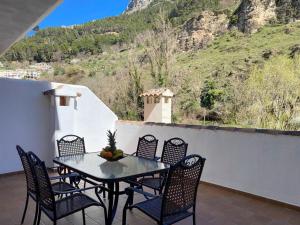una mesa y sillas en un patio con una montaña en VFT Castillo de la Yedra, en Cazorla