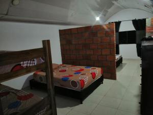 a room with two bunk beds and a brick wall at Casa de relajación low cost in La Dorada