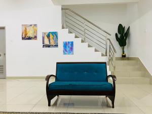 niebieską kanapę w pokoju ze schodami w obiekcie Alyn Home Kluang I Netflix Wifi Coway w mieście Kluang