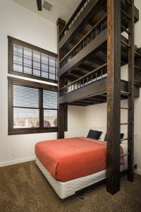 een slaapkamer met een stapelbed met een oranje sprei bij Unique Downtown Rental - La Dolce Vita Villas #5 in Moab