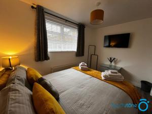 a bedroom with a bed with a couch and a window at Stylish Bungalow near M42, HS2, Airport, NEC & JLR in Sheldon