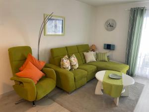 uma sala de estar com um sofá verde e uma mesa em Lechbruck am See Feriendorf Hochbergle Haus 95 em Lechbruck