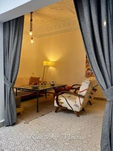 a living room with a couch and a table and curtains at Riad Chic en Médina, Spa & Charme Marocain in Marrakesh