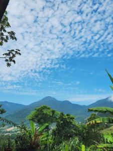 a view of the mountains with a blue sky and clouds at Casa temporada Ilhabela in Ilhabela