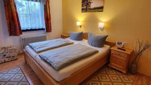 a bedroom with a bed with blue sheets and a window at Lechbruck am See Feriendorf Hochbergle Haus 51 in Lechbruck