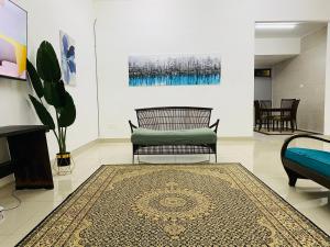 a living room with a chair and a rug at Alyn Home Kluang I Netflix Wifi Coway in Kluang