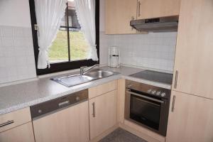 una pequeña cocina con fregadero y ventana en Lechbruck am See Feriendorf Hochbergle Haus 139, en Lechbruck