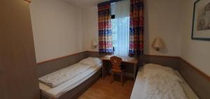 ein kleines Zimmer mit zwei Betten und einem Fenster in der Unterkunft Lechbruck am See Feriendorf Hochbergle Haus 85 in Lechbruck