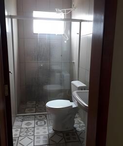 uma casa de banho com um WC, um chuveiro e um lavatório. em Apartamentos em SC em Itajaí