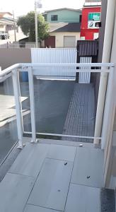 uma varanda com um corrimão branco numa casa em Apartamentos em SC em Itajaí