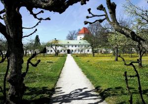 un camino que conduce a una gran casa blanca con techo rojo en Bei München Ferienwohnung in Dachau "Burgmair", en Dachau